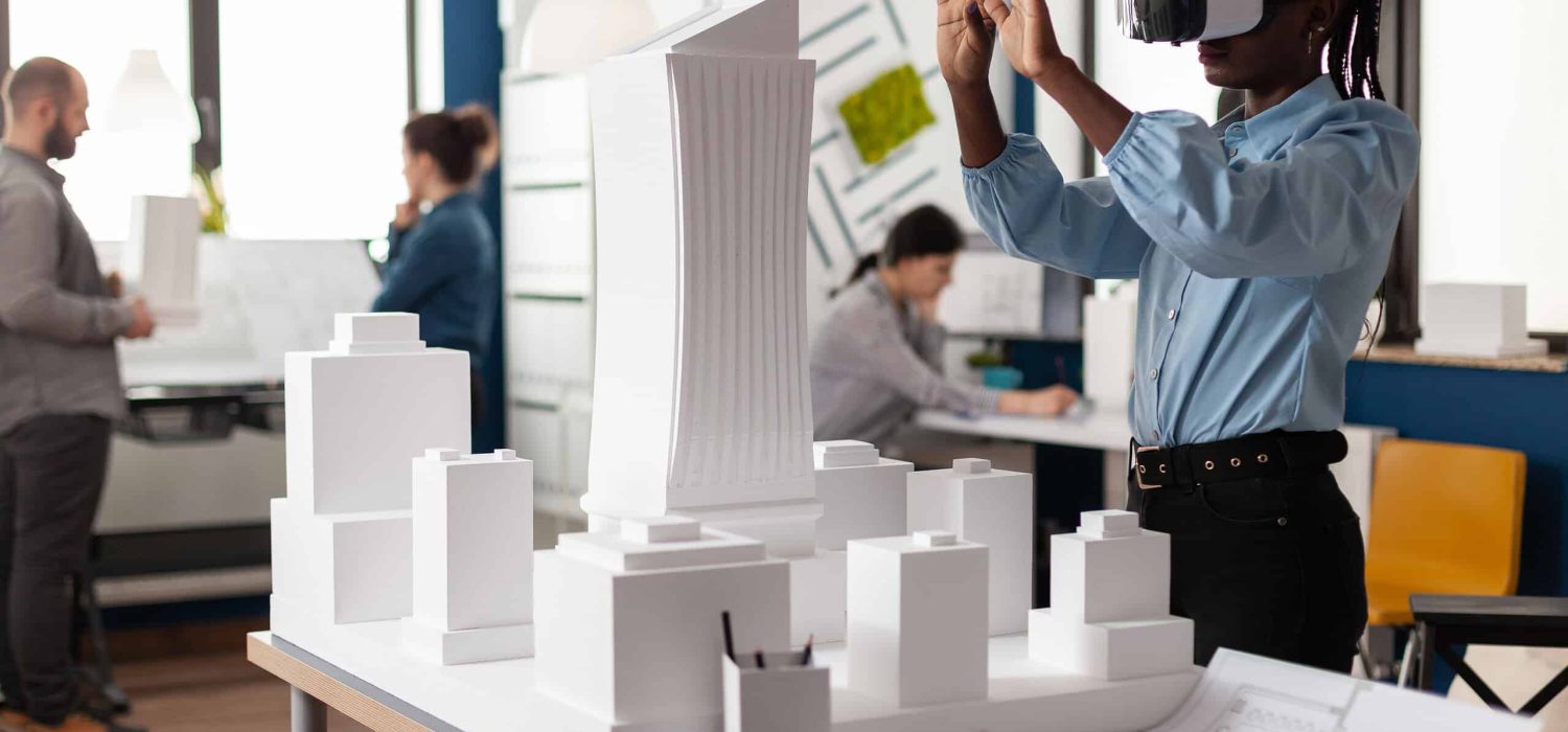 African american woman using vr glasses at work for 3d visual simulation. Standing businesswoman working on building model maquette with modern digital plan design technology